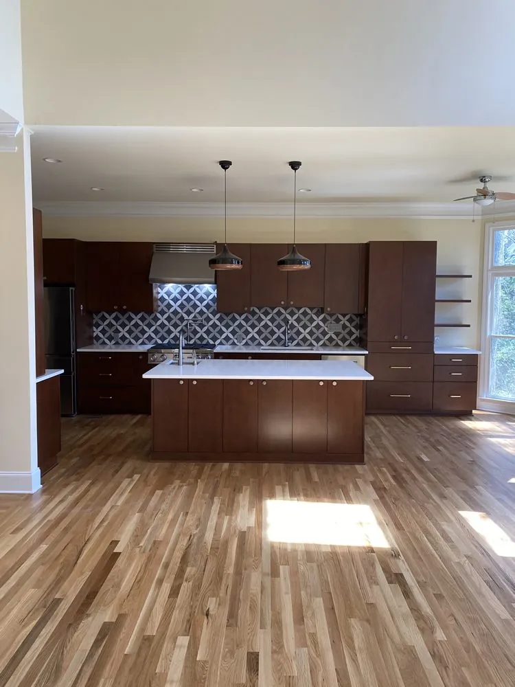 Espresso cabinetry with a patterned tile backsplash and a wide island