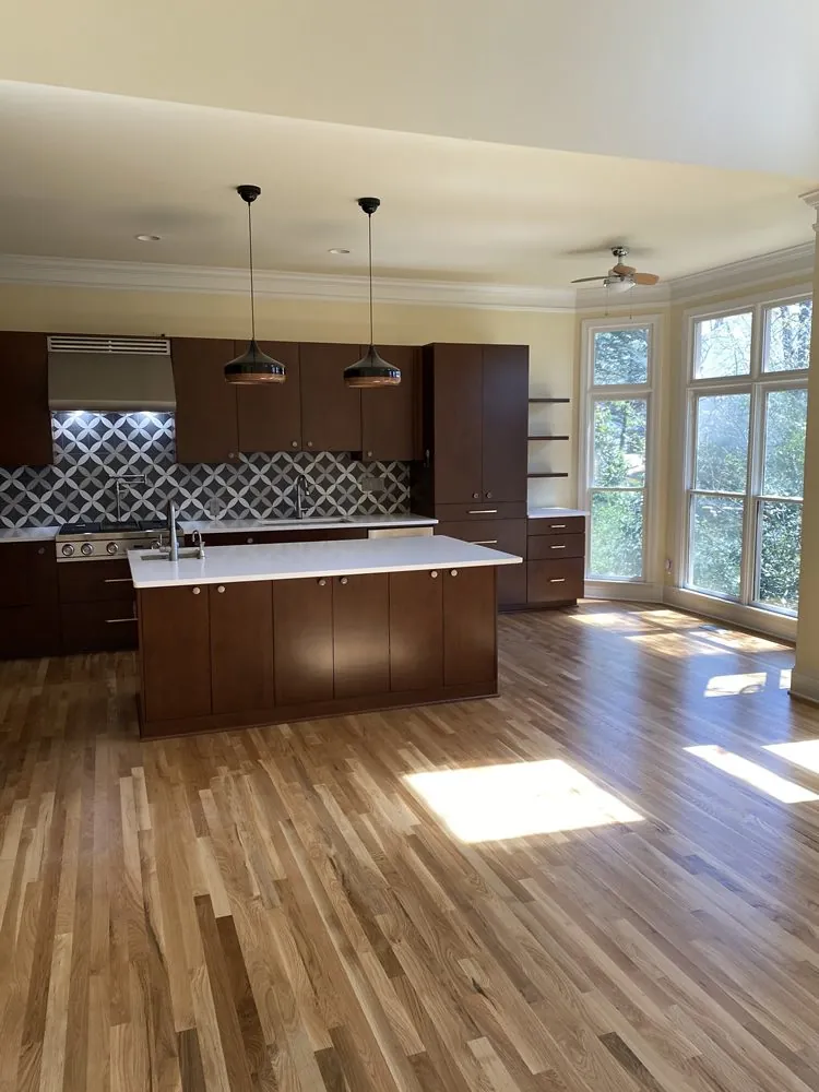 Open kitchen with pendant lighting, floating shelves, and hardwood floors
