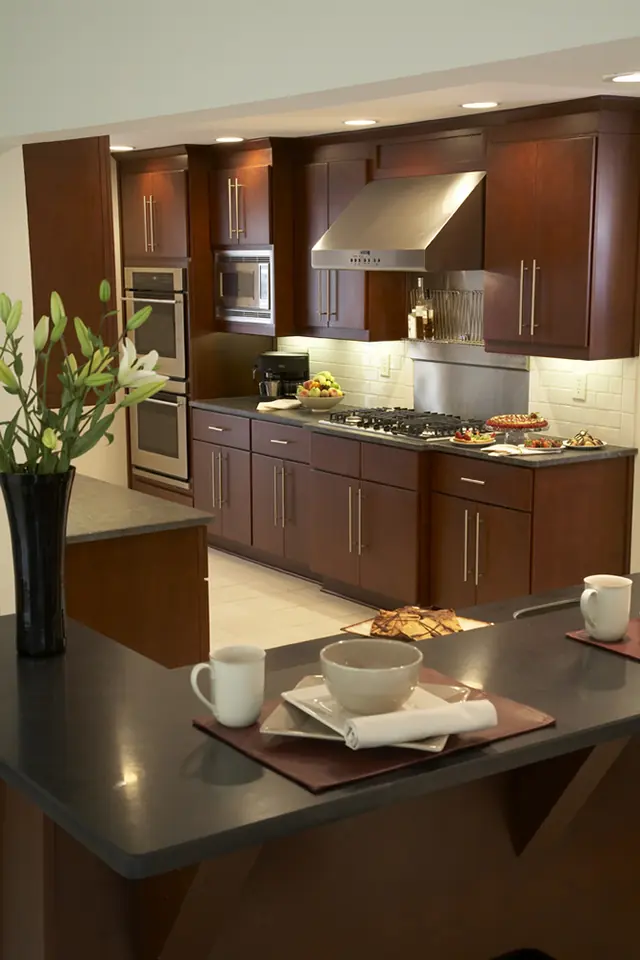 Warm cherry kitchen with a peninsula counter and integrated cooktop